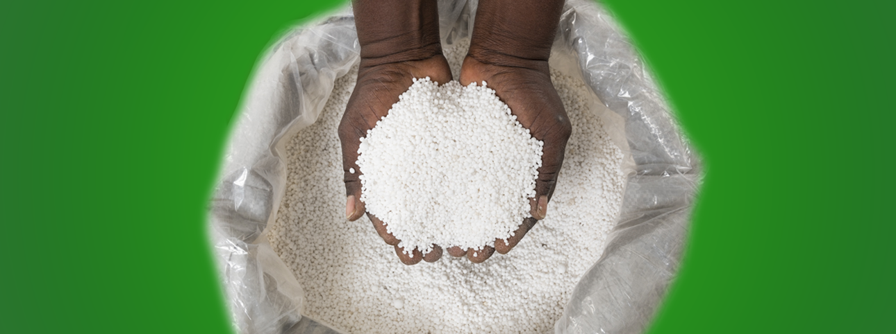 Hands holding NutriMaster fertiliser granules over an open bag